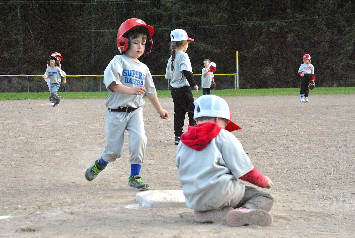 Who's running to third, Gavin Steele is heading for home, and I don't know what the third baseman is digging in the dirt for. T-ball can be quite a riot! (Mineral Independent/Amy Quinlivan)