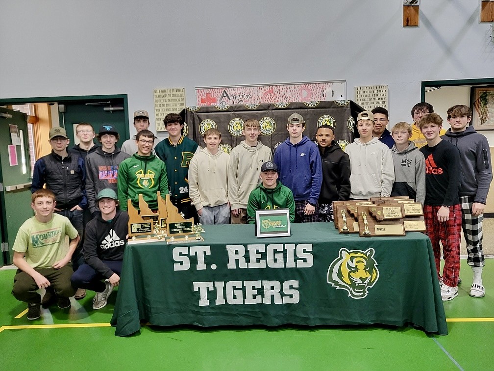 St. Regis senior John Pruitt, seated at table, is surrounded by his Tigers' teammates during his scholarship signing ceremony with Rocky Mountain College last week in St. Regis.  (Photo courtesy of the Pruitt family)