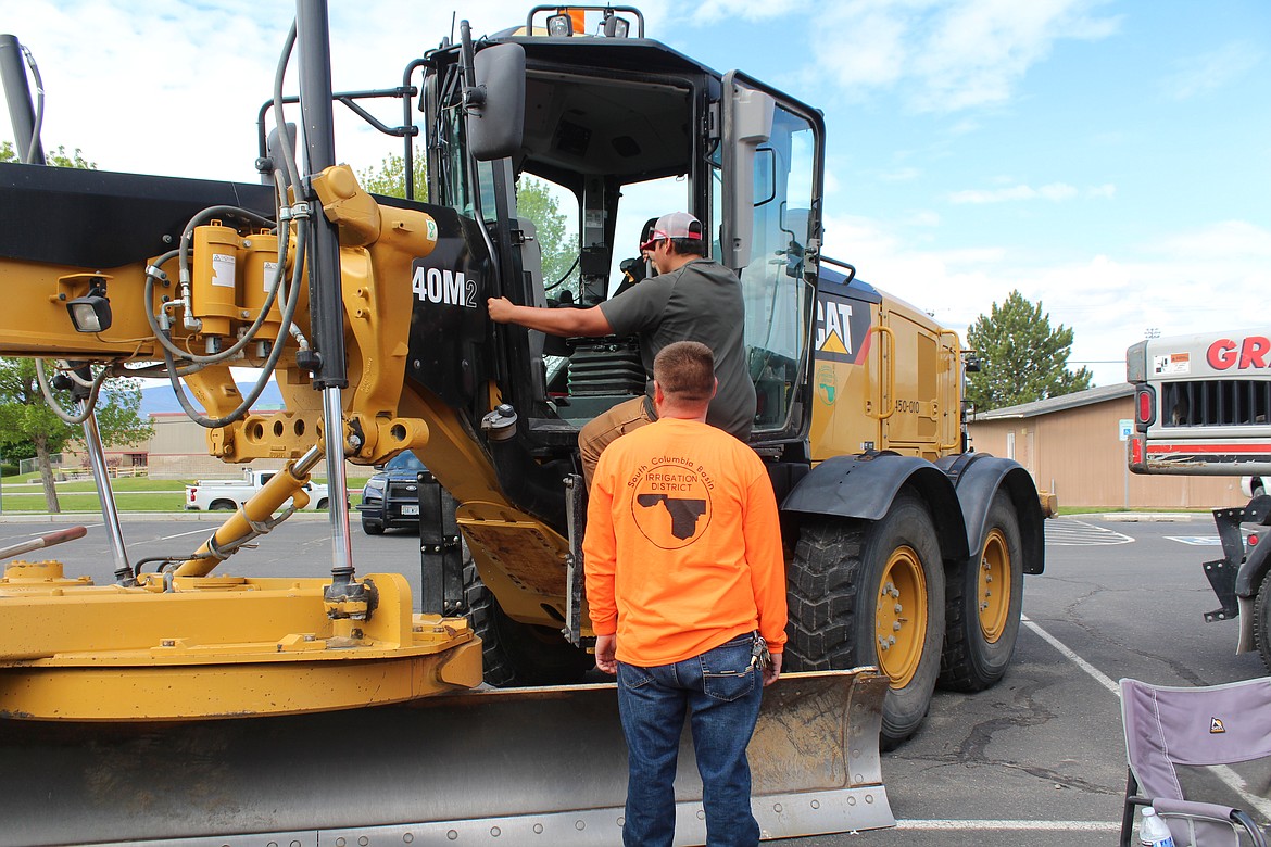 A Wahluke student climbs into a piece of South Columbia Basin Irrigation District heavy equipment during Outdoor Career Day,