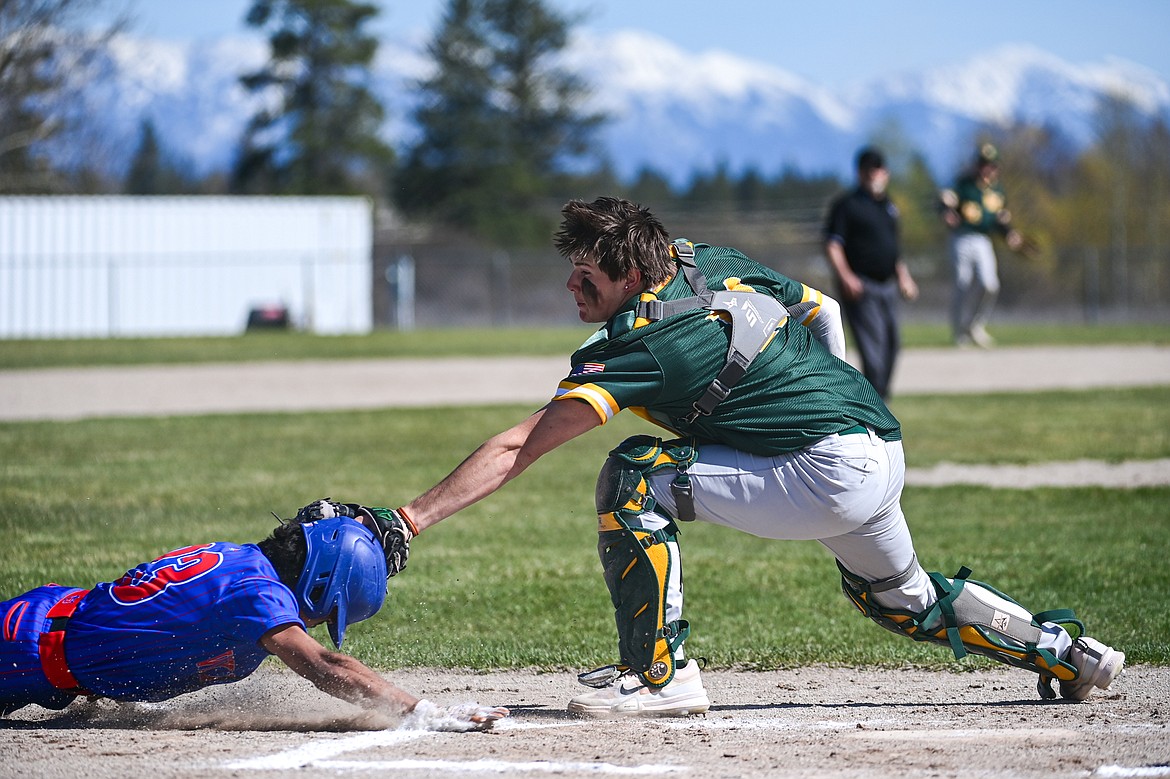 Whitefish catcher Avery Caton (11) puts the tag on the head of Bigfork's Ryeln Rodriguez (23) as he was trying to score from second base on a throw by Bulldogs centerfielder Calvin Eisenbarth in the first inning at ABS Park in Evergreen on Tuesday, April 23. (Casey Kreider/Daily Inter Lake)