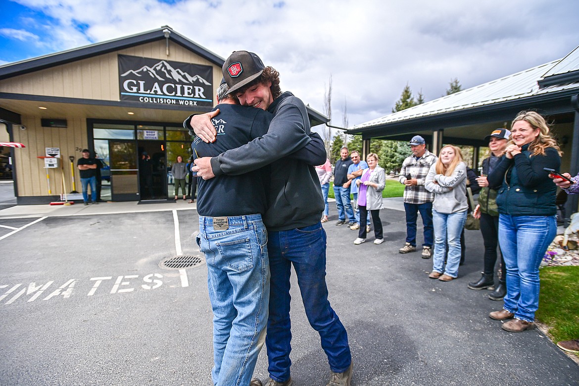Tanner Lair smiles as he receives a hug and the keys to his refurbished Ford F-250 from Glacier Collision Worx Production Manager Tim Stoddard after the Make-A-Wish foundation provided $10,000 in funding to revamp the truck for Lair, who is in remission from non-Hodgkin lymphoma. (Casey Kreider/Daily Inter Lake)