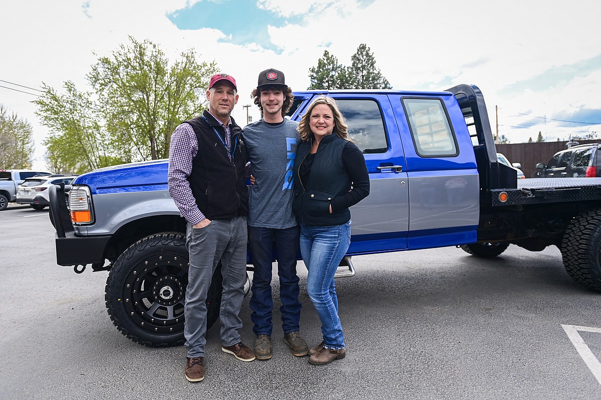 Tanner Lair with his stepfather Alan Sempf and mother Kayla Caudill in front of his newly-refurbished Ford F-250 outside Glacier Collision Worx in Evergreen on Tuesday, April 30. The Make-A-Wish foundation provided $10,000 in funding to revamp the truck for Lair, who is in remission from non-Hodgkin lymphoma. (Casey Kreider/Daily Inter Lake)