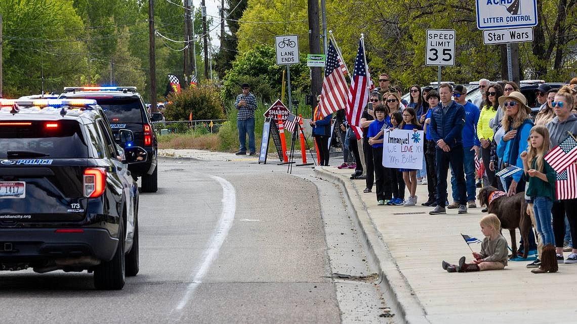 People wishing to pay respects to fallen Ada County Sheriff’s Deputy Tobin Bolter watch a procession pass through Star on Tuesday.