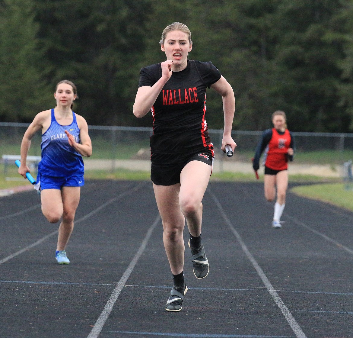 Wallace senior Britany Phillips crosses the finish line in first after anchoring the 4x100 relay.