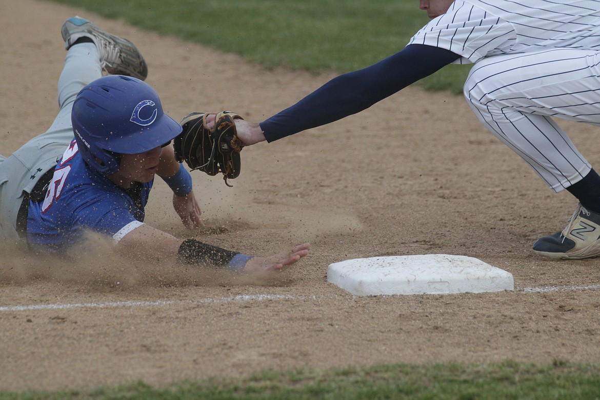 MARK NELKE/Press
Seth Stevens of Coeur d'Alene slides into third base as Mark Holecek of Lake City applies the tag in the first game Tuesday at Lake City High.