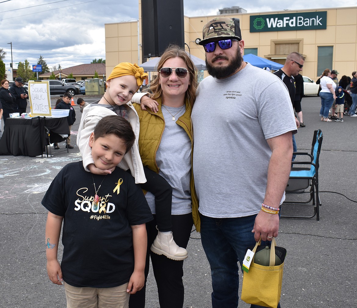 Eleanor Marcum, shown here with her mom Nicollette Marcum, her dad Ethan Marcum and her big brother Trygve Helms, 8, was a little tired but still all smiles at the fundraiser Saturday. Her other brother Atticus Helms, 12, wasn’t able to be there, her parents said.