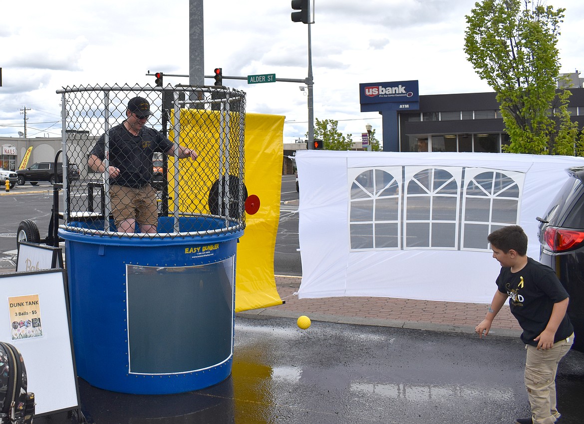 Trygve Helms hits the target and drops Junior Firefighter Justin Orth into the dunk tank at Saturday’s fundraiser for Trygve’s little sister Eleanor Marcum.