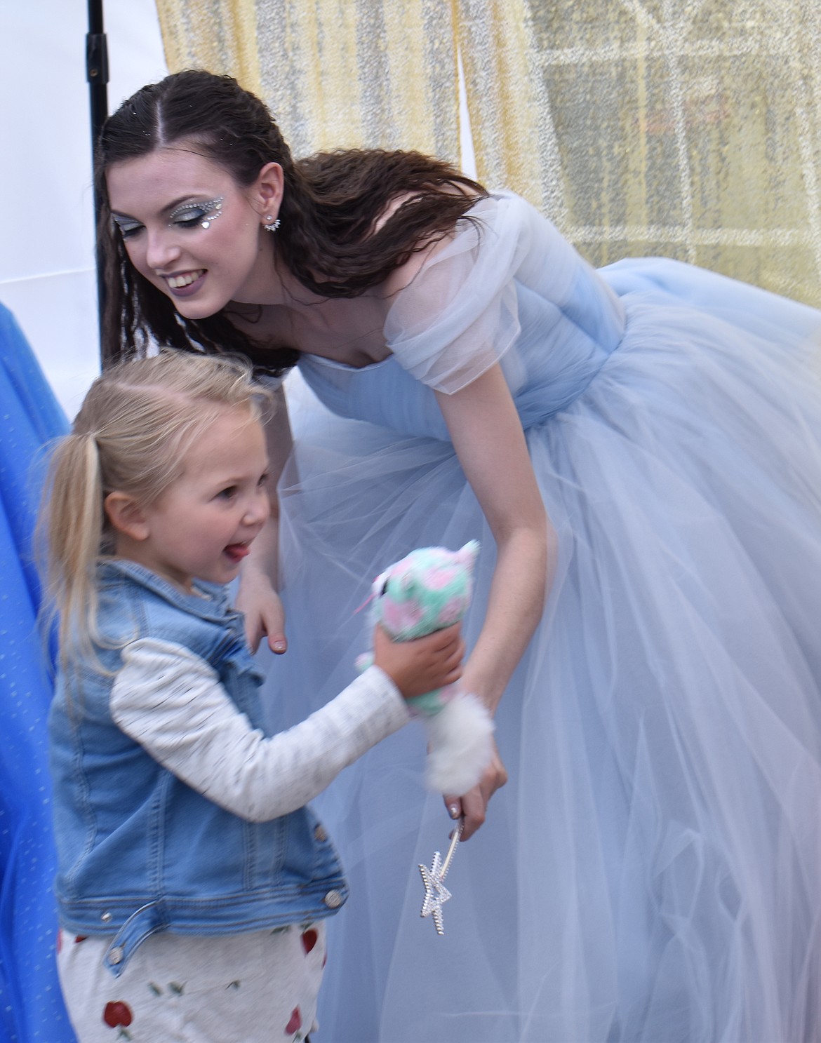 Camryn Fletcher, 5, of Moses Lake gets a hug from (temporary) Princess Autumn Mueller in the photo booth at Eleanor Marcum’s fundraiser Saturday.