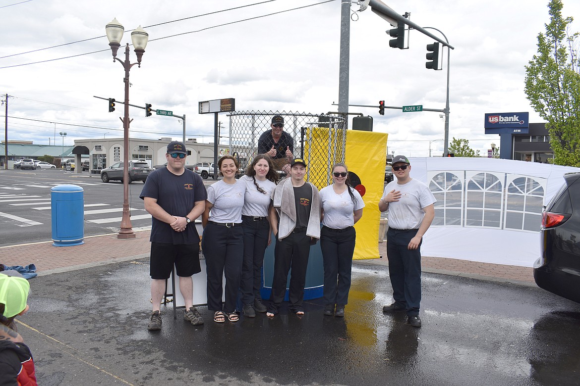 From left: Junior and recruit firefighters Kyle Parker, Haley Jones, Lorelai White, Justin Orth (in dunk tank), Talon Guel, Hannah Toro and Jaxyn White gather for a photo at the fundraiser for Eleanor Marcum’s cancer expenses Saturday.