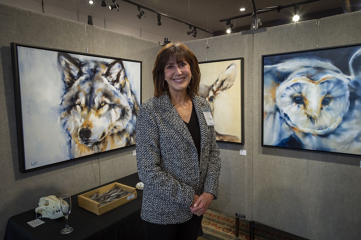 Helena artist Kallie Audet stands in front of her paintings during a September 2023 show at Cawdrey Gallery in Whitefish. Audet's newest work will be on display at the gallery through May. (Photo provided)