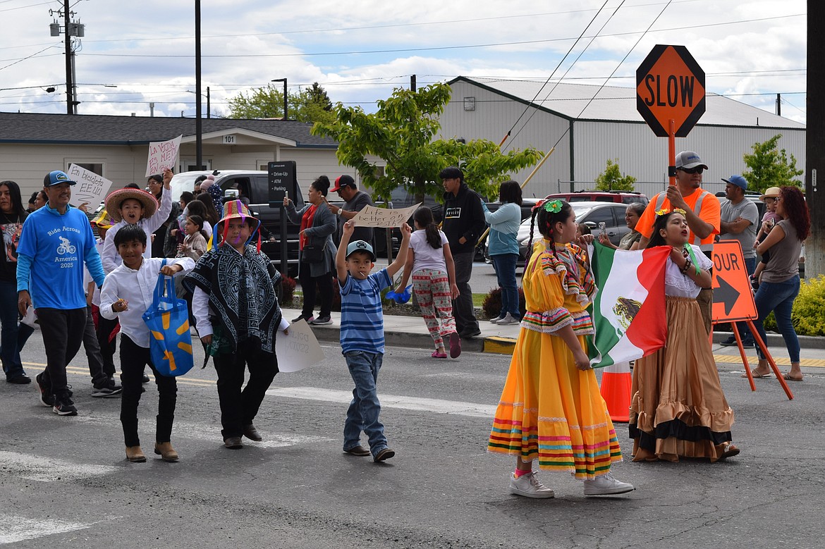 Local Mattawa youth dancers hold the Mexican flag at the front of the parade procession traveling west on Government Road Saturday during the community’s Children’s Day celebration.