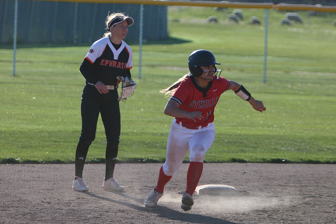 Othello senior PK Garza, in red, rounds second base on her way to third base against Ephrata on Monday.