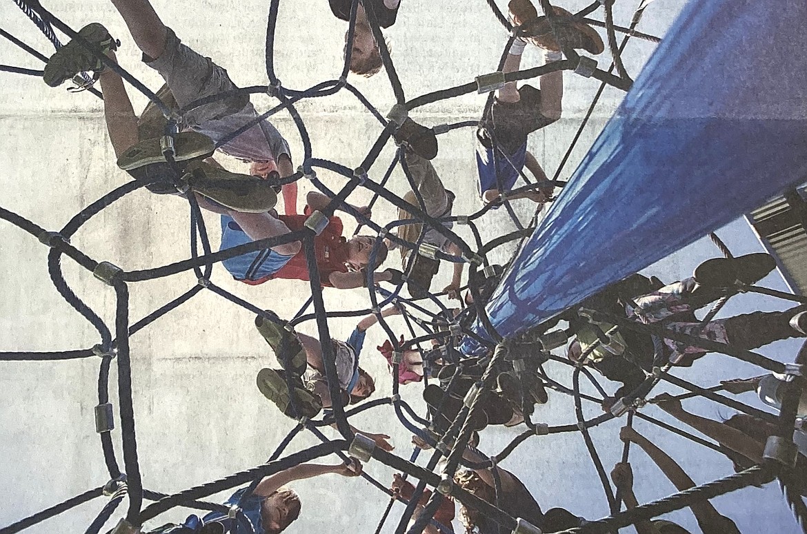 A swarm of Sorensen Magnet School children ascend a webbed play structure during the soft opening of McEuen Park.