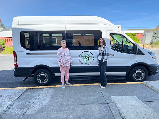 Kathy Anderson, left, manager of the Ephrata Senior Center, and Chelan Kleyn with the Paul Lauzier Foundation stand in front of the van that the foundation purchased for the center in January.