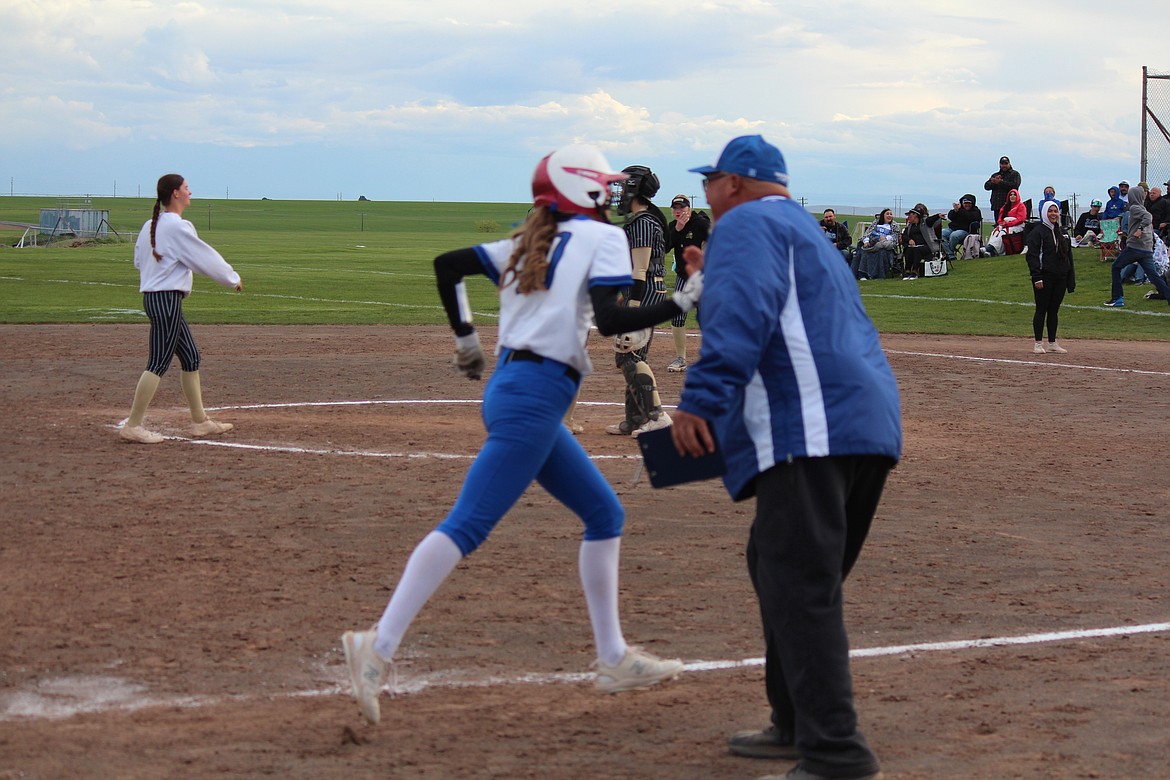 Warden Coach Randy Wright, right, gives a high-five to Valerie Rodriguez (10) as she rounds third after a home run.