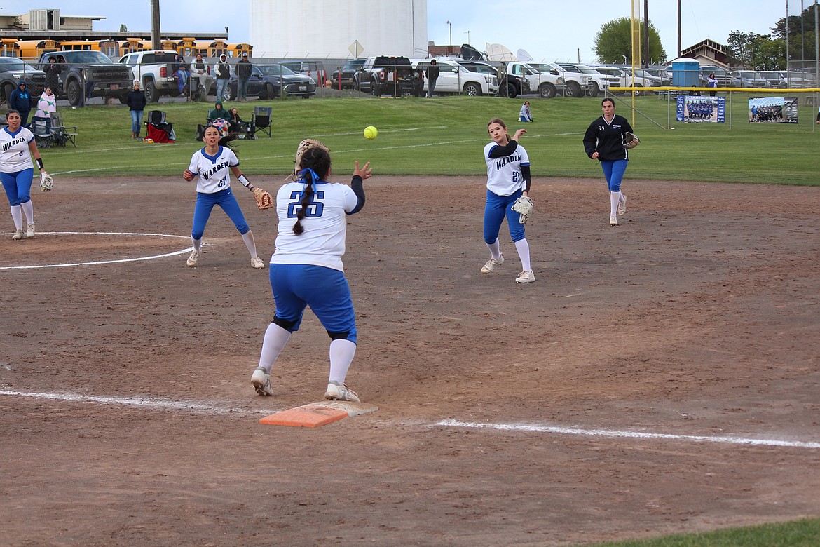 Warden first baseman Genisis Ozuna (25) takes the throw from Miranda Martinez (21).