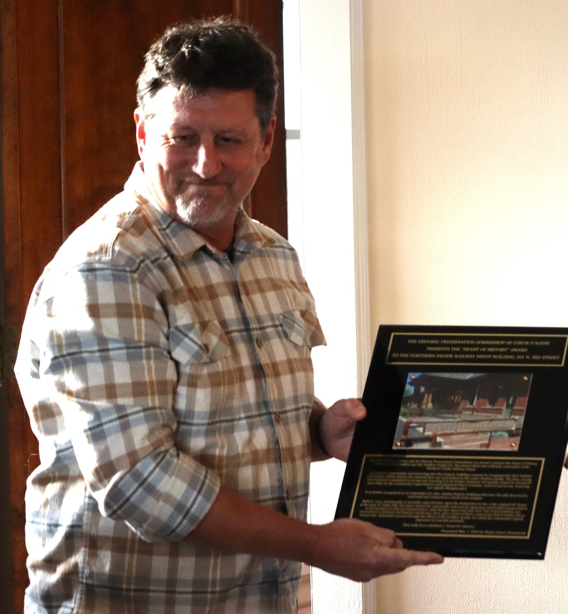 John Swallow holds the Heart of History plaque he received Wednesday night at the Jewett House.