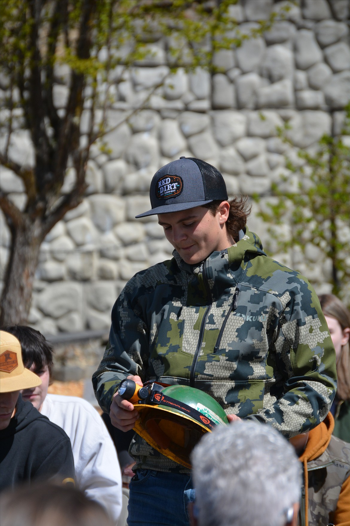 Andrew Lewis turns off the light on the mining headlight signifying their passing  at the mining memorial in Big Creek.