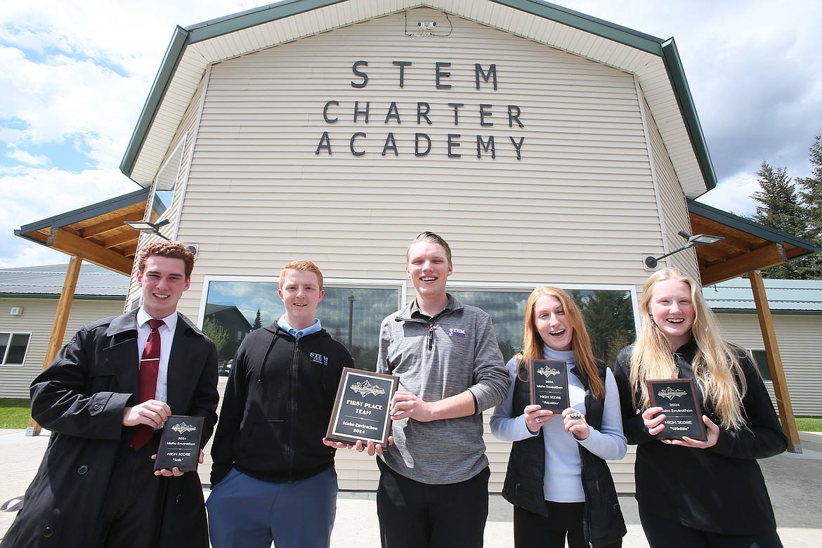 North Idaho STEM Charter Academy students show off the many awards they earned when they came in first place at the 2024 Idaho Envirothon, held Monday and Tuesday in Challis, Idaho. The students are seen Thursday outside of their school. From left: Nicolas Gronlund, Micah Collins, Colton Burnside, Jessalyn Myers and Keira Barnhart.