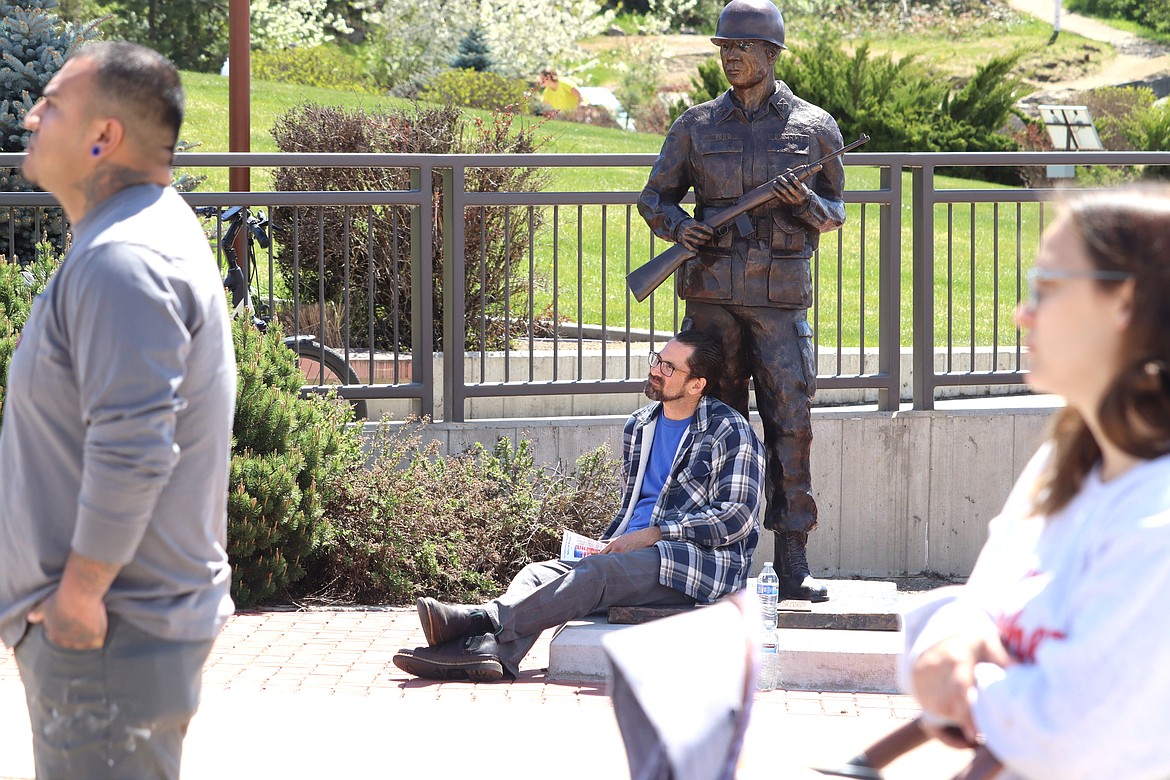 Jonathan Zepeda sits at the base of a soldier statue at McEuen Park’s Veteran Memorial Plaza during a National Day of Prayer rally on Thursday.