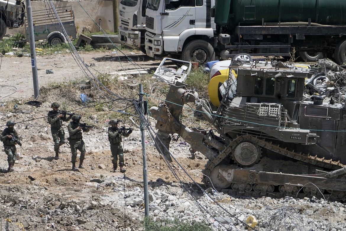 Israeli solider aims their weapons during military operation in the town of Deir al-Ghusun, near the West Bank town of Tulkarem, Saturday, May 4, 2024. (AP Photo/Majdi Mohammed)