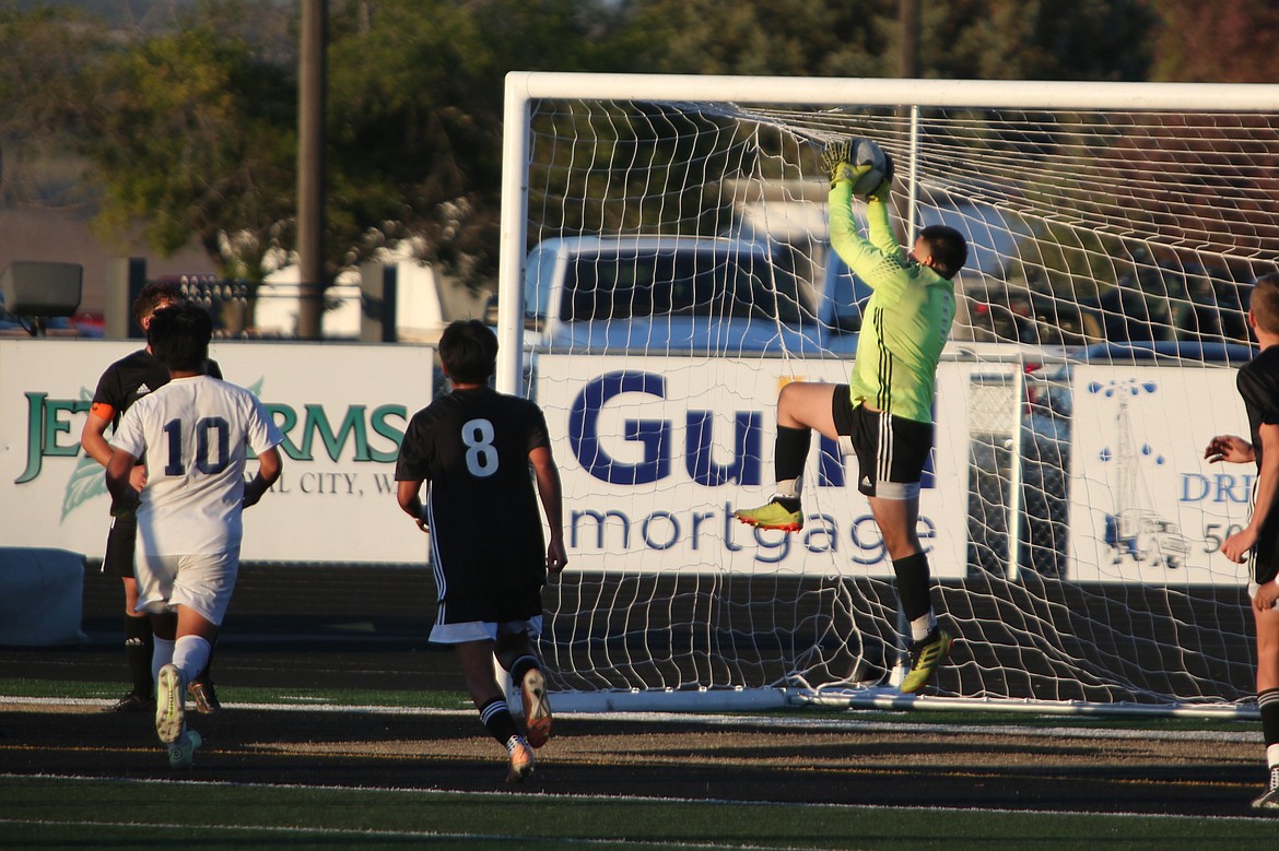 Royal junior Alex Arceo, in neon green, leaps up to save the ball on a Wapato corner kick late in the second half.