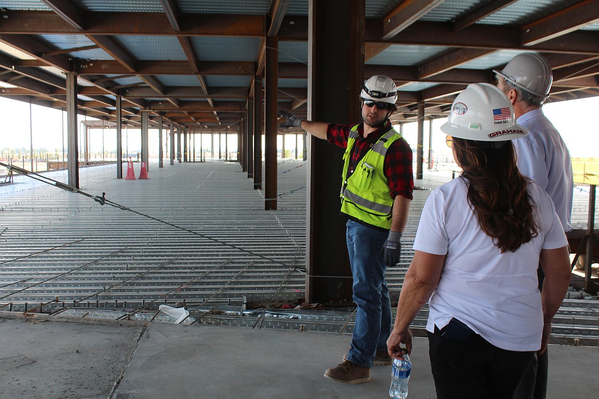 Luke Carlson of Graham Construction, center, shows where the next section of subfloor will be poured at the new Samaritan Hospital during a tour of the site. The last piece of steel framing was tacked into place Friday afternoon.