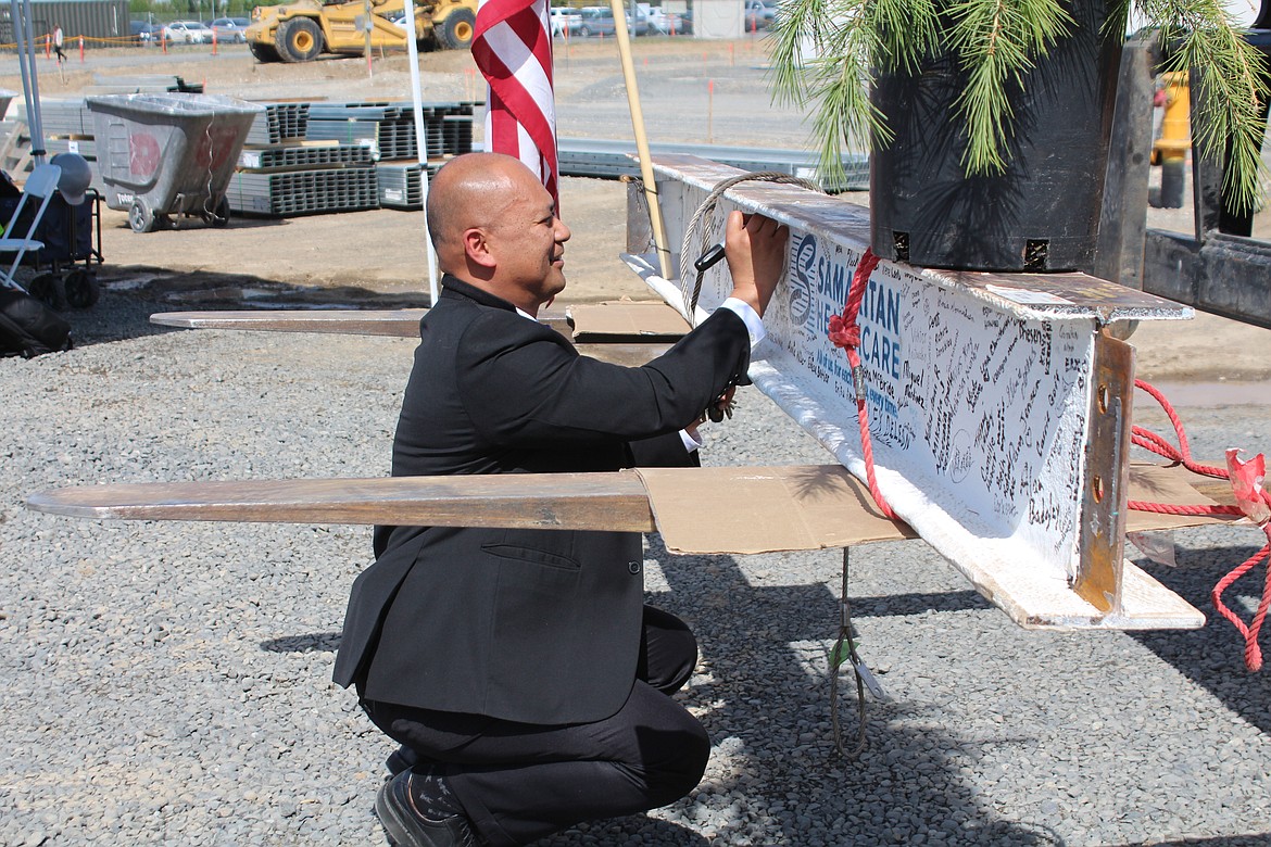 Samaritan Healthcare Chief Administrative Officer Alex Town adds his name to the last beam.