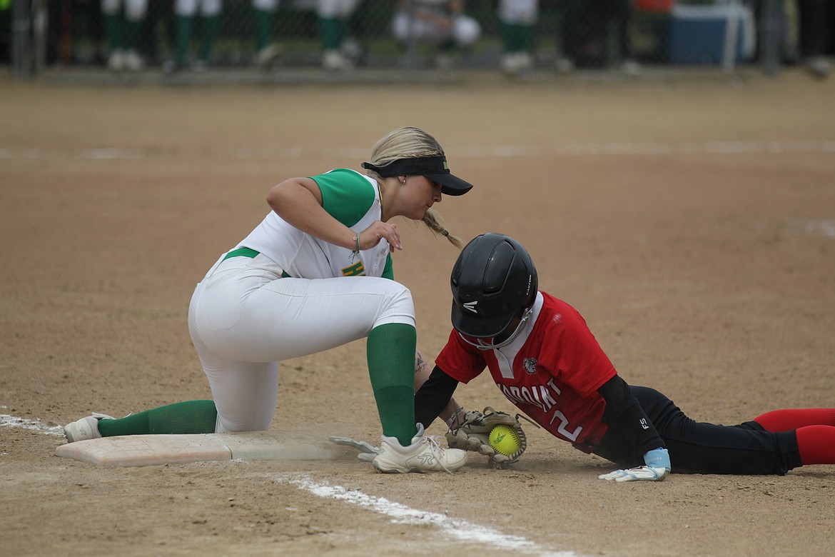 Baylie Hindle of Sandpoint dives back to first base as Mia Kesner of Lakeland applies the tag on Saturday in Rathdrum.
