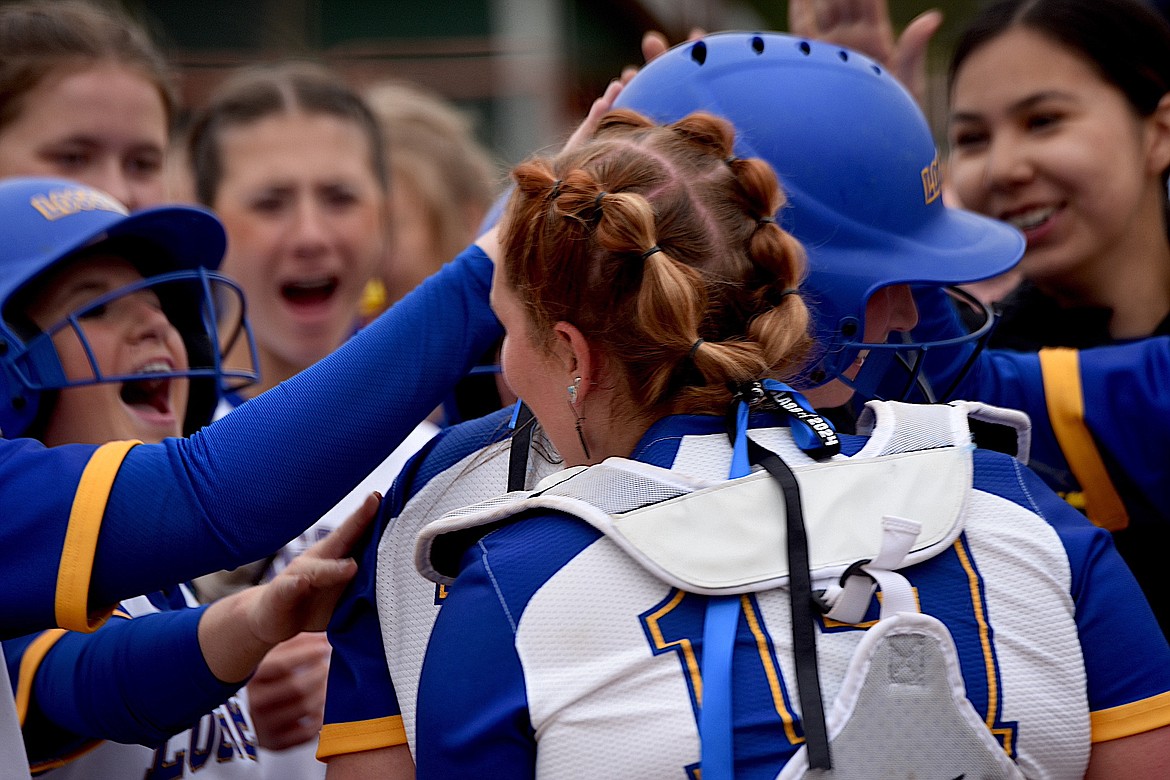Libby high school softball player Jossalyn White, center wearing helmet, is mobbed by her teammates after hitting a home run in the second inning to give the Loggers a 5-4 lead. (Scott Shindledecker/The Western News)