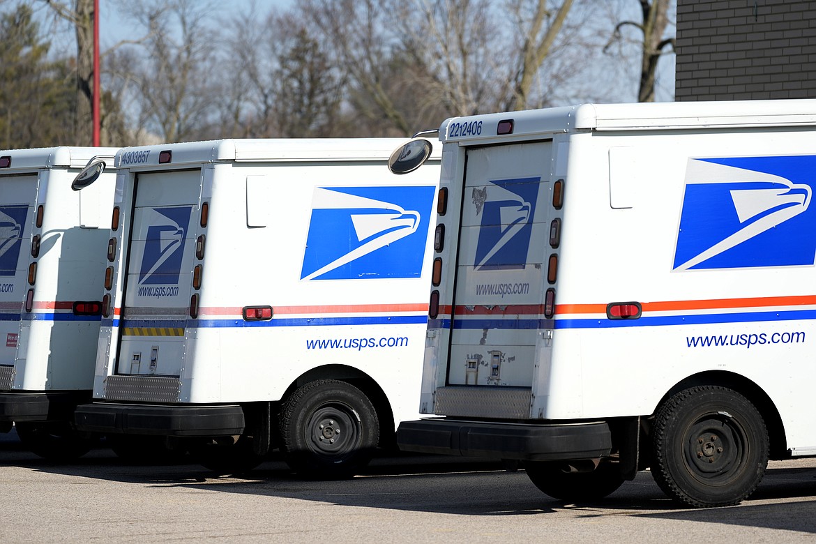 U.S. Postal Service trucks park outside a post office in Wheeling, Ill., Monday, Jan. 29, 2024. (AP Photo/Nam Y. Huh)