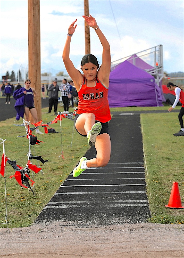 Annie Adams flies in the long jump during last Thursday's all-county meet. The Ronan athlete picked up a first in the 300-meter hurdles and second in the 1,600-meter run. (Susan Lake photo)