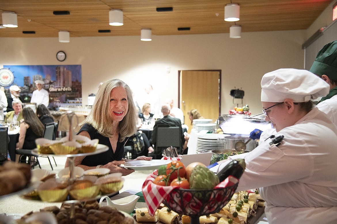 A guest smiles while getting food at the Flathead Valley Community College Foundation spring Festival of Flavors event.