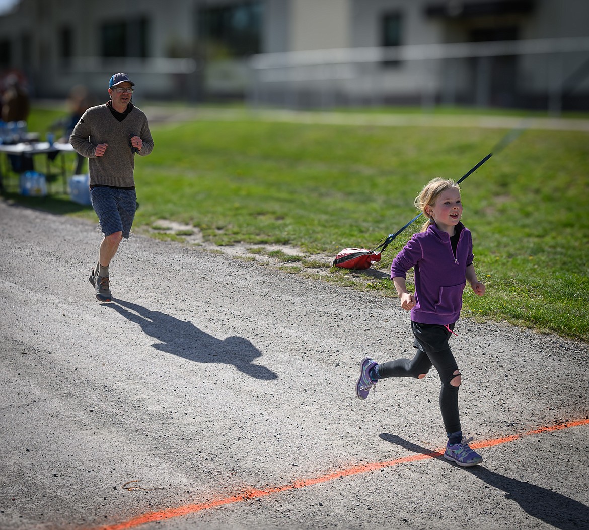 Fern Rigles, 7, leads her father, Seth, to the finish line of the Dixon Stampede. (Tracy Scott/Valley Press)