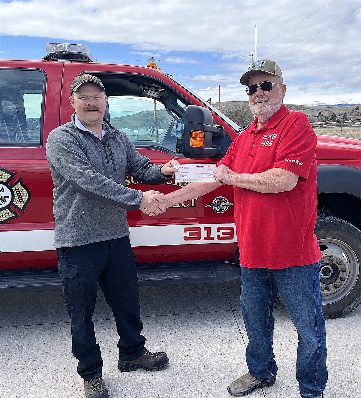 Chief Will Woodger of the Polson Rural Fire District appreciated the infusion his department received recently from Elks, represented by Gail Nelson. (Courtesy photo)