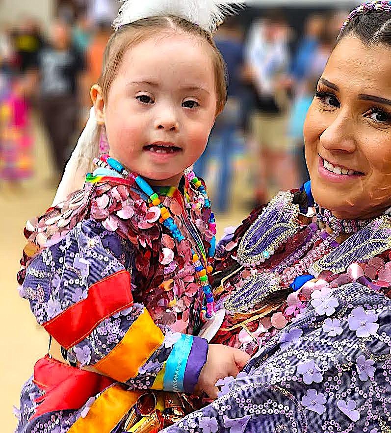 Kenna Baylor-Corum, 3, dances with her mom, Catherine Baylor, at the Head Start Powwow. The pair and sister Melina Baylor had matching sparkly powwow regalia. (Berl Tiskus/Leader)