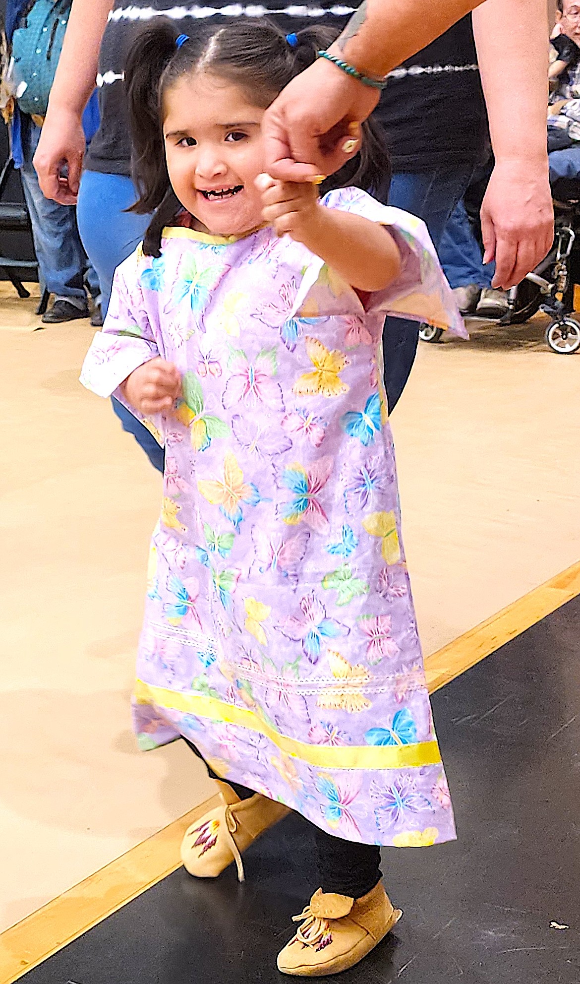 Cataleya Soto, 3, holds onto her mom's hand as they enter the Head Start Powwow on Friday, May 3, at the Ronan Event Center. (Berl Tiskus/Leader)