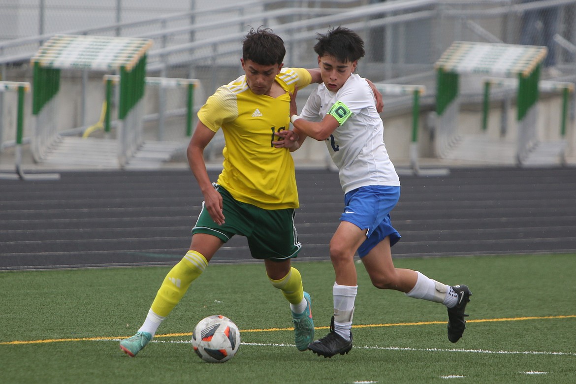 Quincy sophomore Erick Zepeda (17) battles for the ball against a Manson defender in the first half of Saturday’s district tournament game.