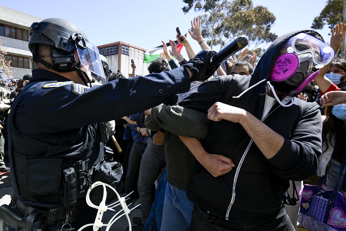 A protester is hit with a baton by a police officer at UC San Diego, May 6, 2024, in San Diego. (AP Photo/Denis Poroy, File)