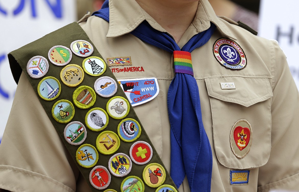 Merit badges and a rainbow-colored neckerchief slider are affixed on a Boy Scout uniform outside the headquarters of Amazon in Seattle. The U.S. organization, which now welcomes girls into the program and allows them to work toward the coveted Eagle Scout rank, announced Tuesday, May 7, 2024, that it will change its name to Scouting America as it focuses on inclusion. (AP Photo/Ted S. Warren, File)