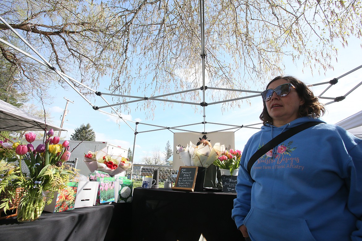 Amber Steele Poelstra, owner, grower and designer with Steelstra Designs in Post Falls, discusses peony tulips Friday at her Athol Farmers Market booth in Athol City Park. The market will be open 2:30-6:30 p.m. Fridays through the end of the season.