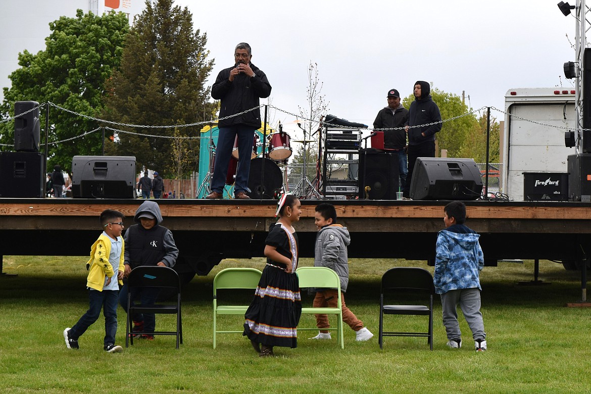 Children play musical chairs while the Othello Cinco de Mayo event announcer directs activities in between music set pieces at the celebration in Lions Park.