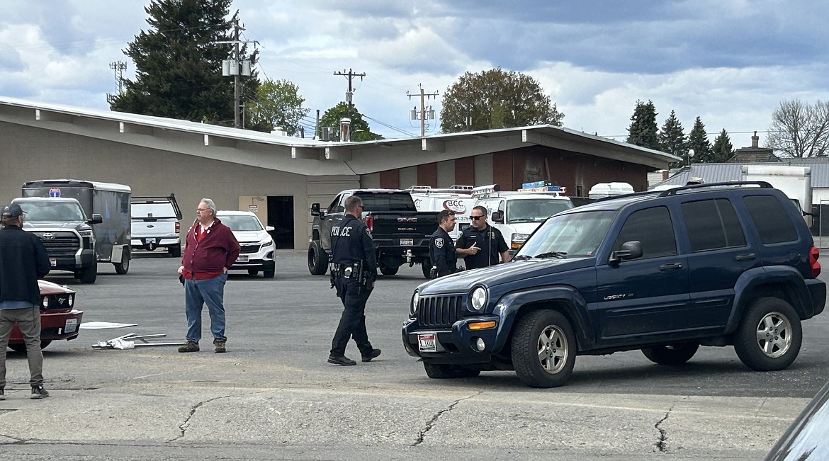 Coeur d'Alene police officers investigate the scene of an accident at Fourth Street and Spokane Avenue on Tuesday afternoon.