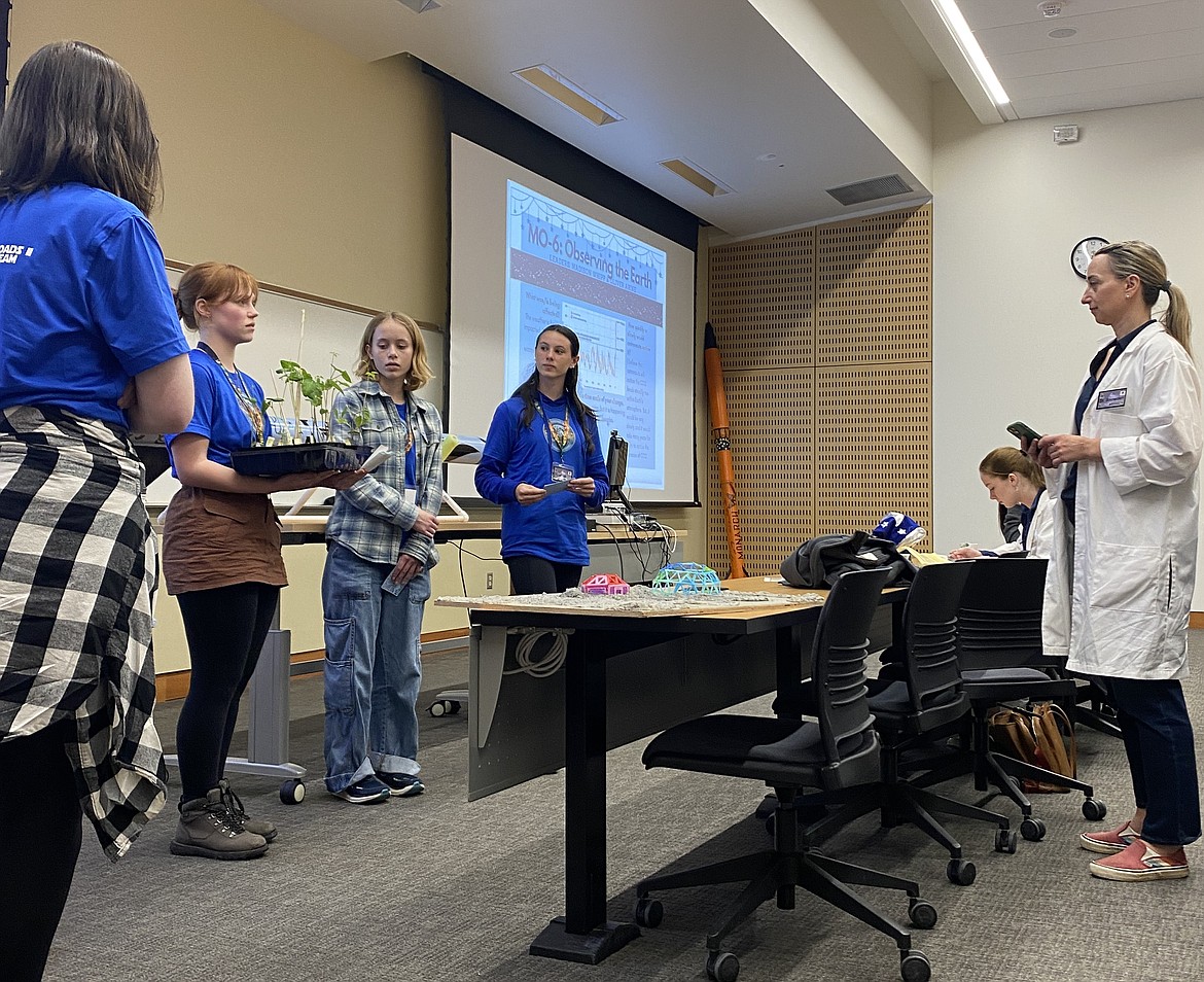 From left, Coeur d'Alene High students Madison Graham (back to camera), Vaylynn Crawford, Ellie Staudacher and Madison Whipp present their findings to Dr. Darci Snowden during the Northwest Earth and Space Sciences Pathways Lunar Flyby In-Person Challenge, held Friday and Saturday at Central Washington University.