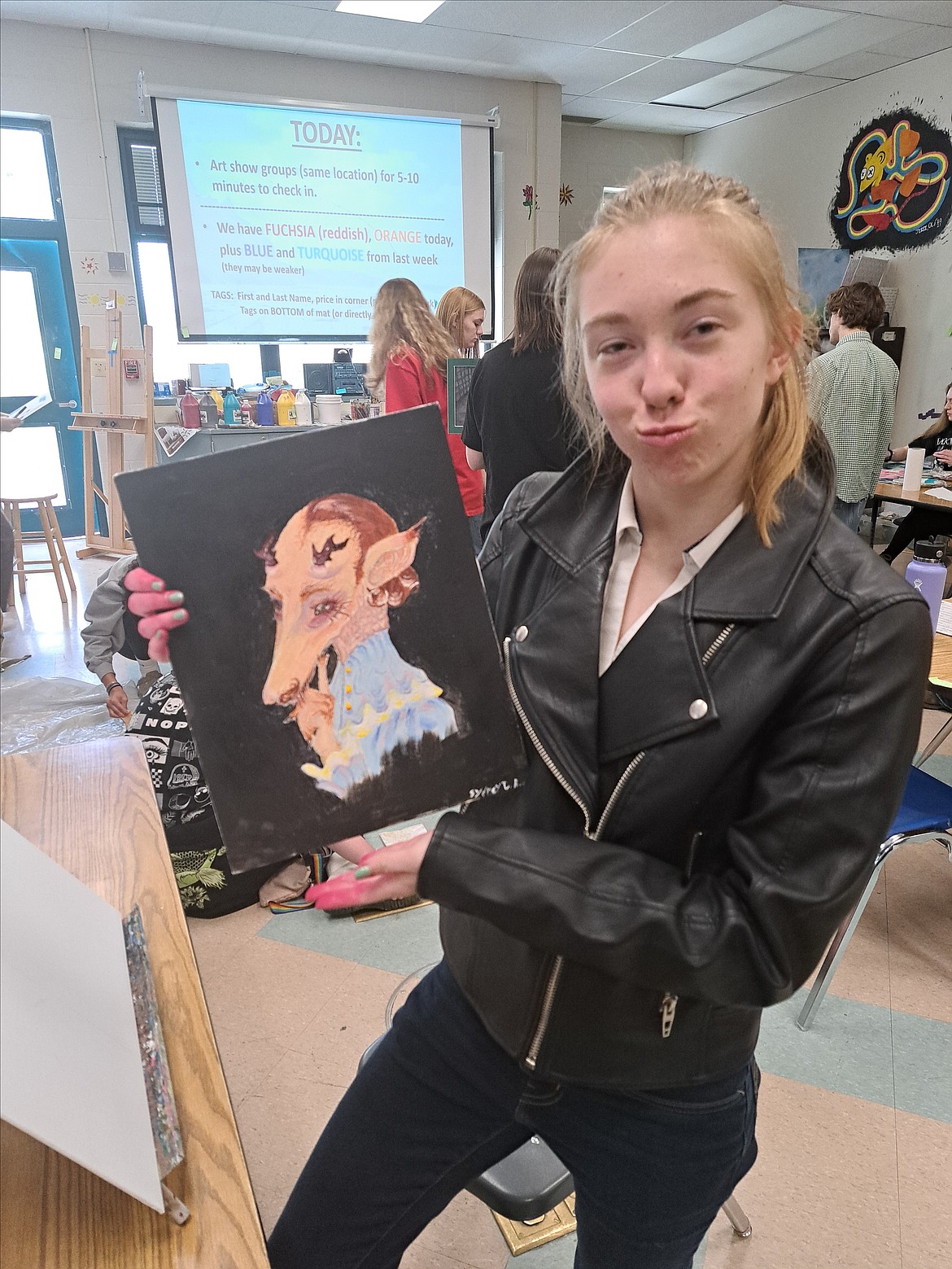 Sydney Beyersdorff shows off her art piece in the theme of "Beauty in the Dark Places," one of the themes for the Lake City High student art show that will be Tuesday evening in McEuen Park.