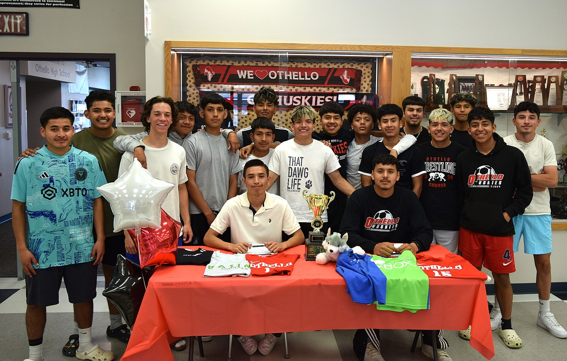 Othello High School Soccer players Felipe Haro, sitting left, and Don Eldred, sitting right, are surrounded by their Othello Huskies teammates during the duo’s signing to Wenatchee Valley College Wednesday.