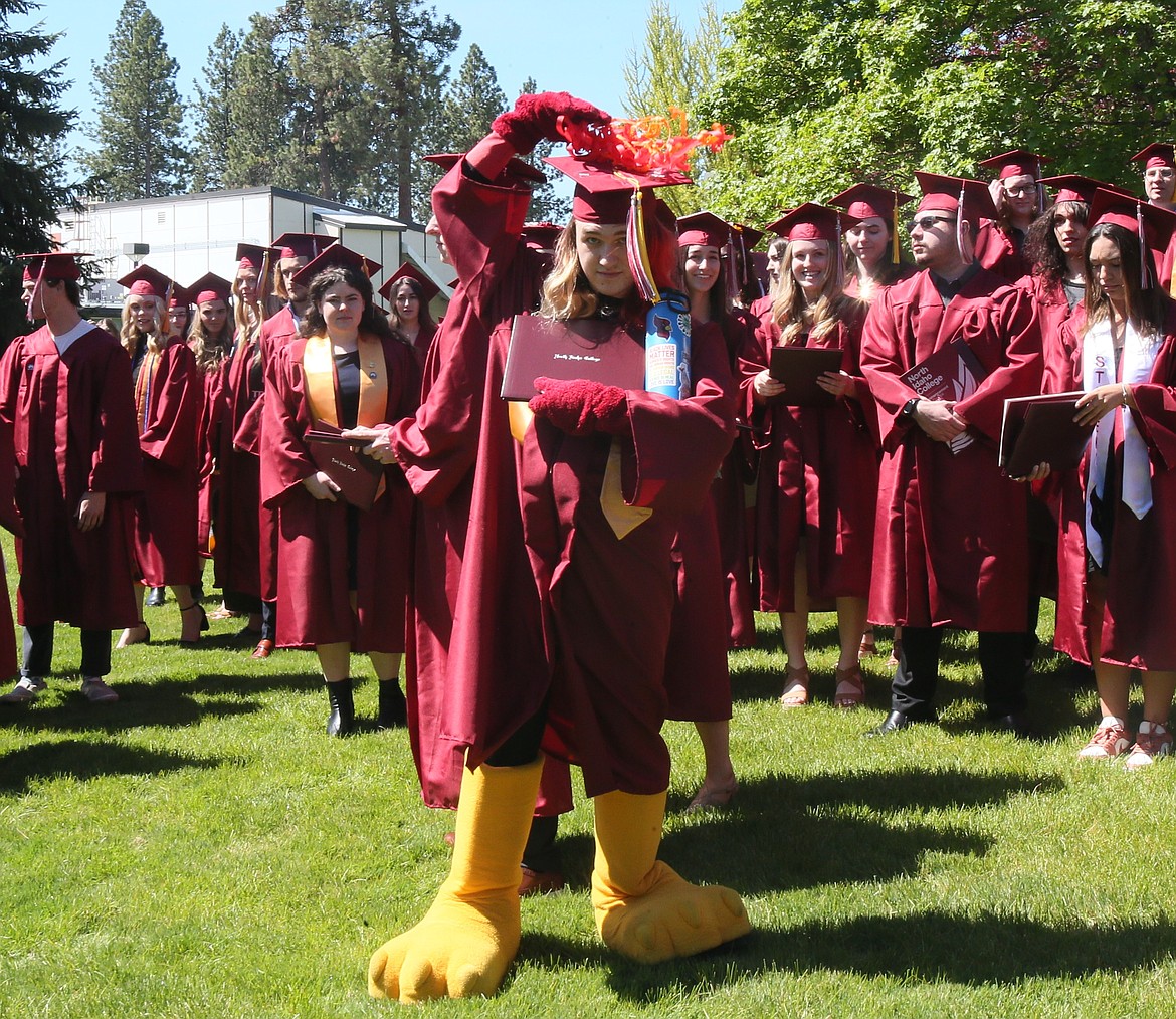 Hunter Johnston, who has performed as North Idaho College mascot Cecil Cardinal since April 2023, wears his mascot gloves and bird feet as he places confetti on his mortarboard Friday morning after the commencement ceremony. "I’m just feeling proud of myself," he said. "And seeing everyone else walking across the stage, that made me feel really happy.”