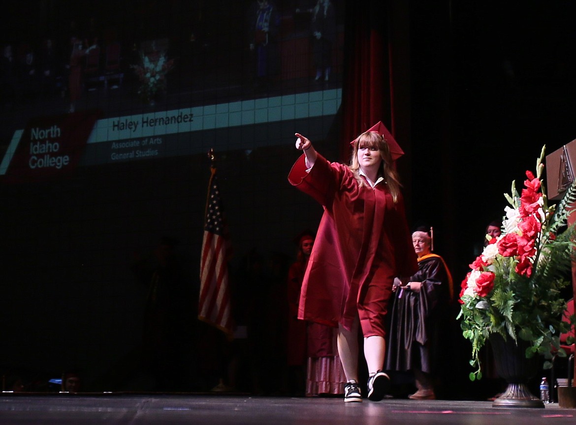 General studies grad Haley Hernandez points to the audience as she crosses the stage during Friday morning's commencement ceremony at North Idaho College.