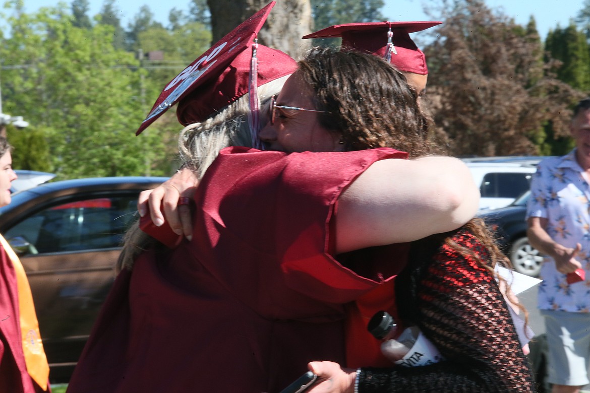 Mimi Hiibel, right, hugs good friend and North Idaho College graduate Teri White during the Friday morning graduate walk to Boswell Hall.