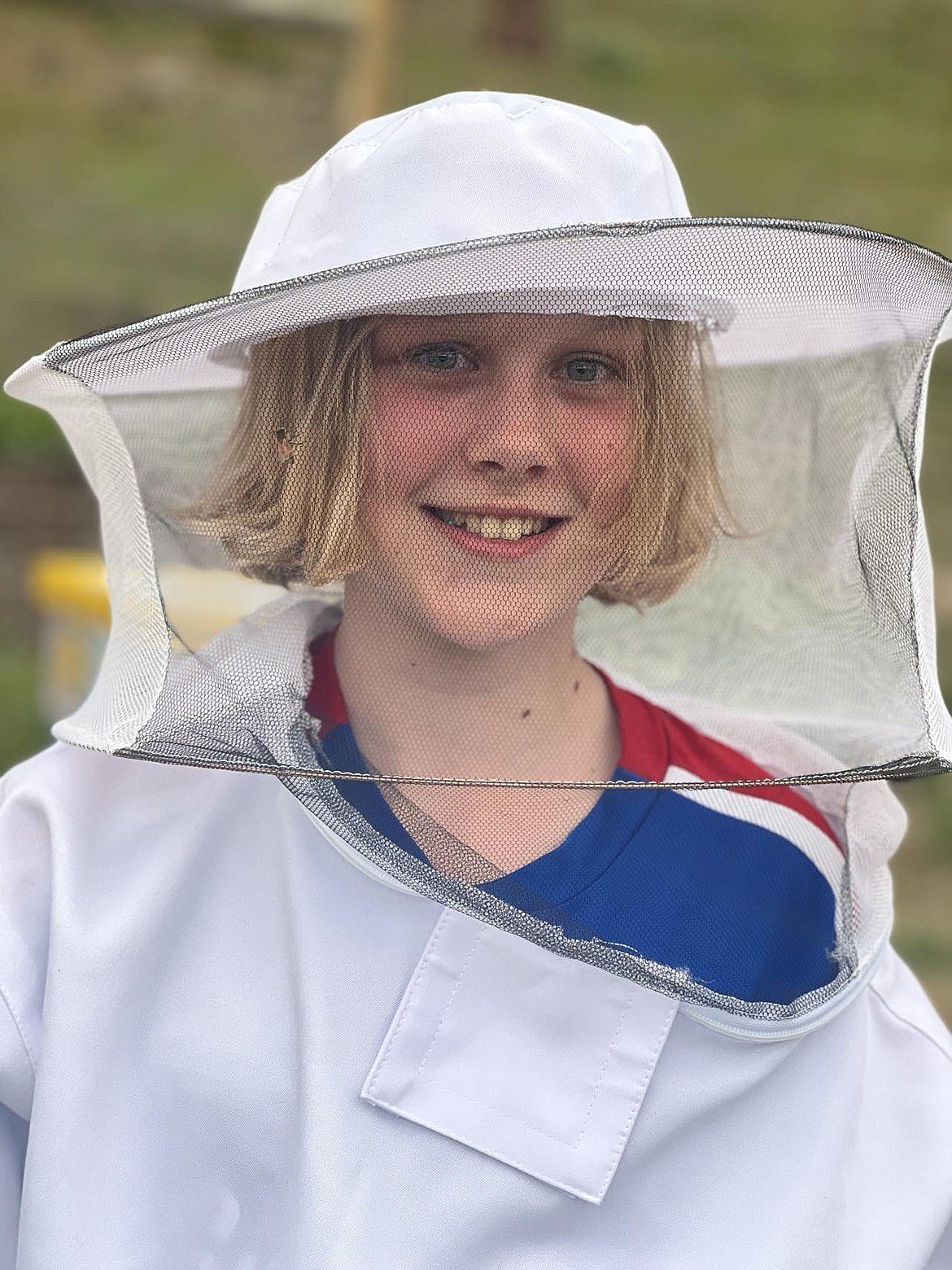 Ayla Henderson, from Superior wears her bee suit for the first time. The traditional protective gear was purchased for her by Katie Benson who is sponsoring Henderson as a junior beekeeper at their apiary. (Mineral Independent/Amy Quinlivan)